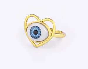 Detailed shot of gold-plated heart evil eye adjustable ring, elegant blue resin eye design.