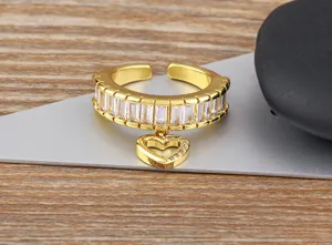 Detaillierte Nahaufnahme eines vergoldeten offenen Rings mit Zirkon und Herz-Anhänger.
