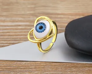 Close-up detail of gold plated evil eye resin heart adjustable ring, unique fashion design.