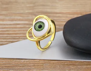 Detailed shot of the gold-plated evil eye open ring with green resin eyeball and heart frame.