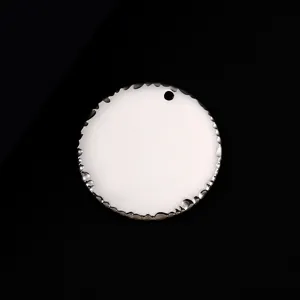 Pendentif rond en acier inoxydable avec bord texturé et trou pour gravure laser.