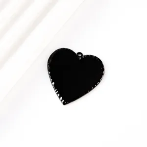Gros plan sur le pendentif cœur noir en acier inoxydable martelé, idéal pour la gravure.