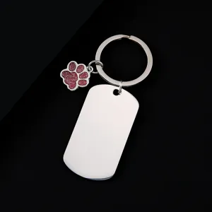 Stainless steel dog tag keychain with glitter paw charm, perfect for laser engraving details.
