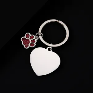 Stainless steel metal keychain detail view featuring a blank heart tag and red glitter dog paw.