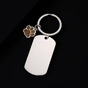 Stainless steel dog tag keychain with cute brown glitter paw pendant, metal keyring detail view.
