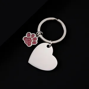 Stainless steel metal keychain detail featuring glitter dog paw charm and blank heart pendant.