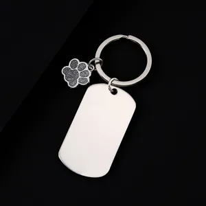 Close-up detail of stainless steel military tag keychain with cute glitter paw charm.