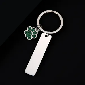 Stainless steel keychain with green glitter paw pendant and blank engravable tag detail view.