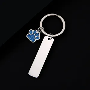 Stainless steel keychain with blue glitter paw charm and blank metal tag for custom engraving.