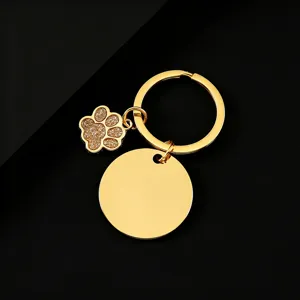 Goldener Edelstahl Schlüsselanhänger mit Glitzer Hunde Pfote Anhänger und runder Plakette.