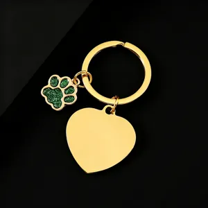 Stainless steel keychain detail showing gold-plated heart pendant and green glitter paw charm.