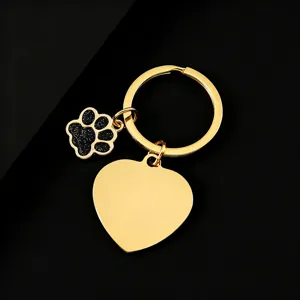 Gold metal keychain with heart pendant and black glitter dog paw charm for daily use.
