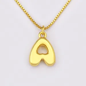 Gros plan détaillé sur le collier chaîne boîte plaqué or avec joli pendentif lettre élégant.
