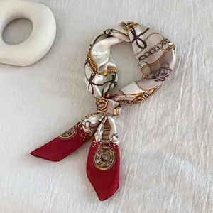 Vista ravvicinata dell'elegante foulard in seta rossa con stampa a catena raffinata.