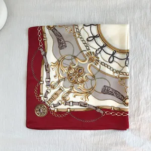 Vista dettagliata del foulard in seta rosso e bianco con classico motivo a catena barocca.