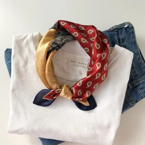 Nahaufnahme des luxuriösen Seidenschals mit klassischem Paisley-Muster und Farblock-Design.