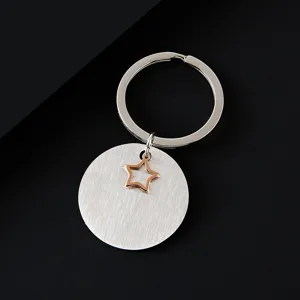 Gros plan détaillé du porte-clés en acier inoxydable brossé avec un pendentif en forme d'étoile.