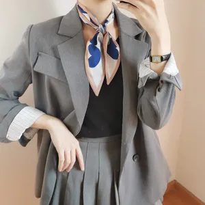Dettaglio foulard in seta da donna con fantasia a cuore blu, elegante accessorio moda.