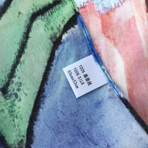 Dettaglio ravvicinato del foulard in pura seta con stampa artistica a olio e orlo arrotolato.
