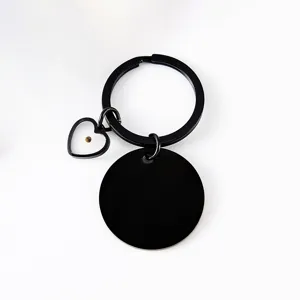 Black stainless steel mustard seed keychain with heart charm and round blank metal pendant.