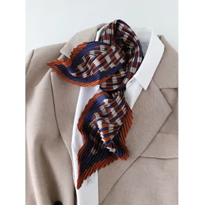 Elegant pleated silk scarf featuring a chic geometric plaid pattern, styled elegantly for women.