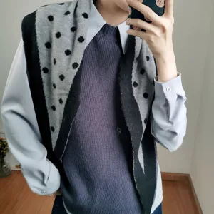 Detalle de cerca de elegante chal de punto de lunares negros y grises para el invierno.