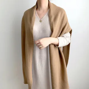 Detail view of the stylish camel knit shawl cape, soft warm winter wrap for women fashion.