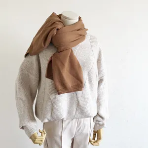 Bruine gebreide sjaal op paspop, knusse warme omslagdoek voor dames in de winter.