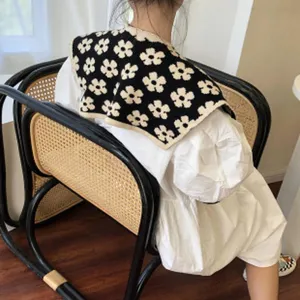 Gepflegter Strick-Falschkragen Detailansicht, schwarz-weißes Blumenmuster, modisches Accessoire.