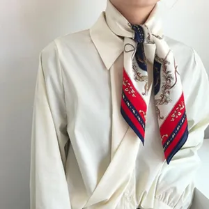 Silk scarf neckerchief close-up, classic baroque chain pattern, elegant white shirt styling detail.