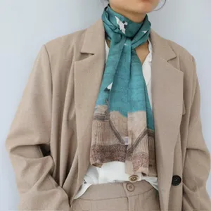 Vue détaillée foulard en soie motif grue verte, élégant accessoire femme pour le cou ou les cheveux.