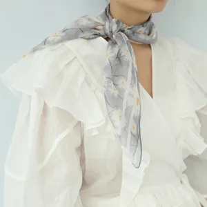 Vista di dettaglio del piccolo fazzoletto quadrato con stampa floreale in seta e chiffon.
