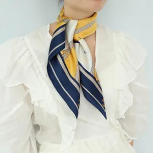 Silk scarf detail shot featuring a luxurious navy and yellow nautical design for women's fashion.