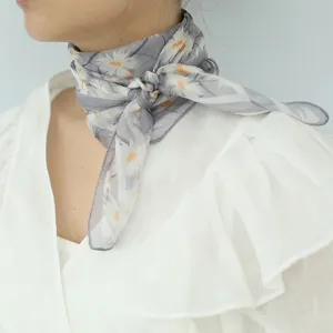 Primo piano di un foulard di seta stampato floreale da donna, tessuto morbido e traspirante.