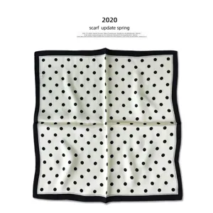 Nahaufnahme des klassischen schwarz-weißen Pünktchen-Seidenfoulards mit elegantem Rand.