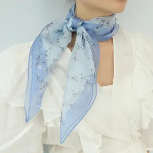 Primo piano di foulard in seta blu traspirante con fiori, quadrato leggero per donna estivo.