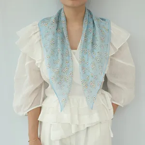 Vista dettagliata del foulard quadrato in chiffon di seta con delicata stampa floreale estiva.