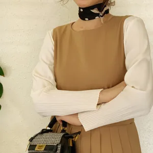 Detailaufnahme einer Frau in elegantem Seidentuch mit Punkten und Lagenkleid Handtasche.