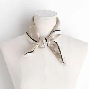 Detailansicht des eleganten Seidenschals mit feinen Punkten und schickem schwarzem Rand.