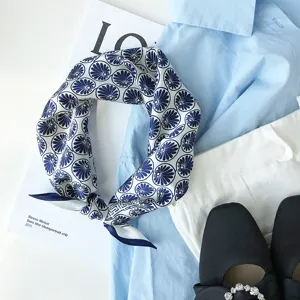 Gedetailleerd overzicht van blauw-witte bloemen zijden sjaal gestyled met overhemd.