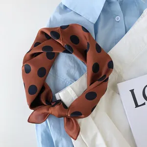 Zijden polka dot sjaal detailweergave met prachtige textuur en retro bruin ontwerp voor dames.