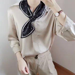Detailaufnahme eines schwarzen Seidenschals mit elegantem weißem Rand, weicher Stoff.