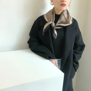 Detailopname van een vintage kippentand zijden sjaaltje gedragen door model voor stijlvolle lente.