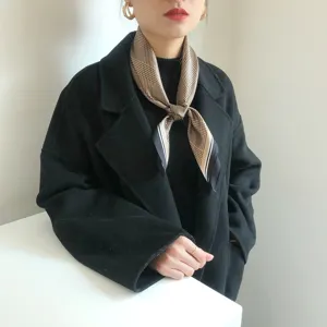 Gedetailleerd uitzicht op een retro zijden sjaaltje met houndstooth motief, elegant.