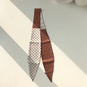 Vue détaillée d'un foulard en soie étroit à pois chic, idéal pour sublimer vos chemises.