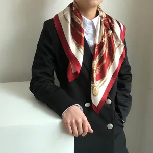 Dettaglio del foulard quadrato in seta rosso vino con classico motivo a catena e bel drappeggio.