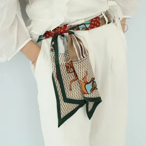 Vue détaillée d'un long foulard en soie multifonctionnel porté en ceinture avec imprimé équestre.