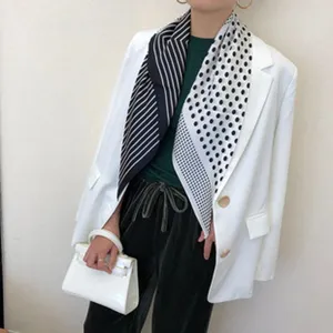 Elegant black and white geometric silk scarf featuring split stripe and polka dot design.