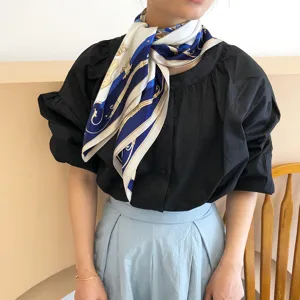 Detail shot of the vintage carriage print silk scarf worn around the neck, elegant style.