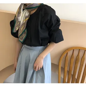 Detailed shot of a vintage silk scarf with elegant carriage pattern worn on a model.